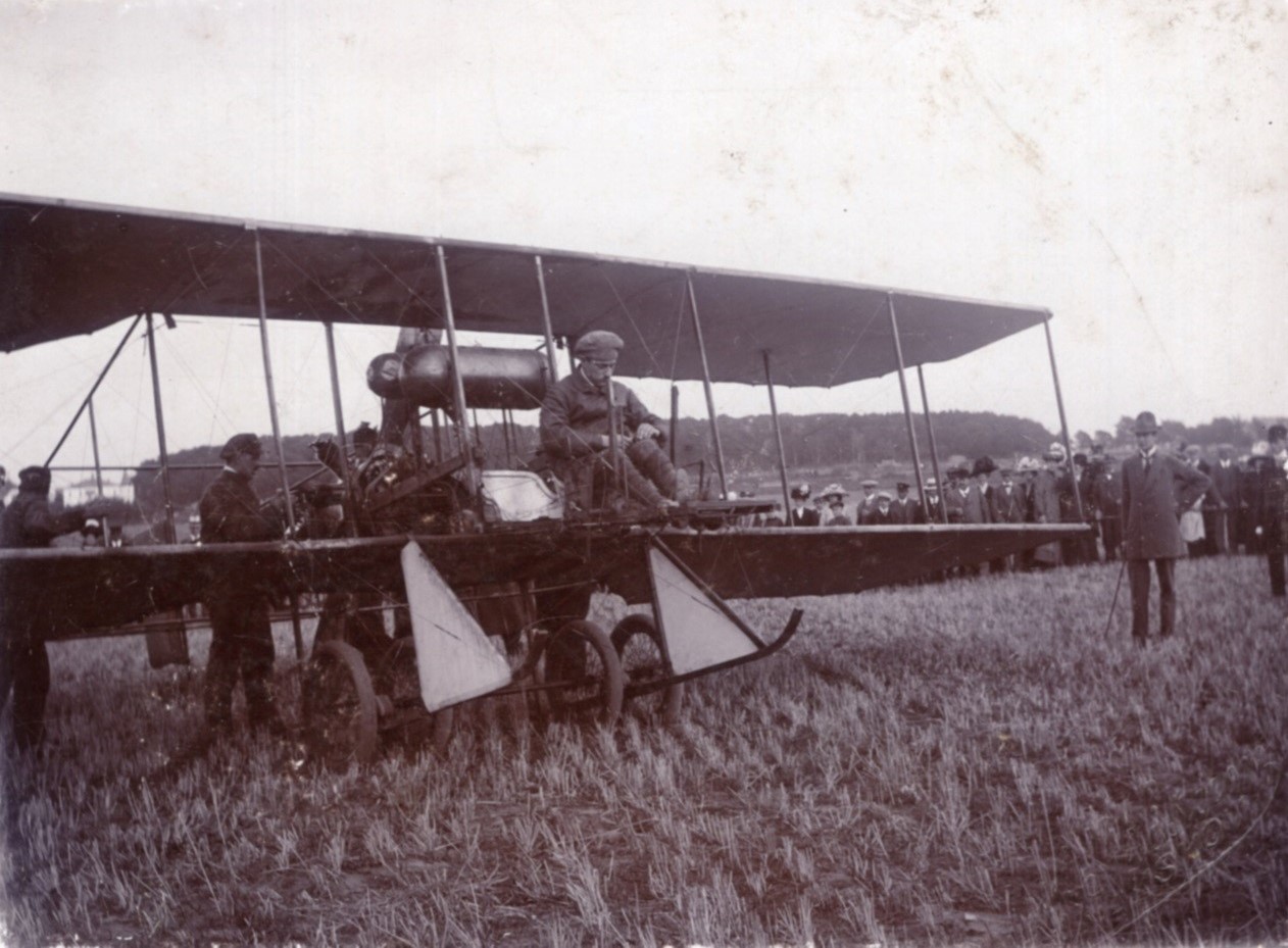 En pilot sidder i en dobbeltdækker flyvemaskine